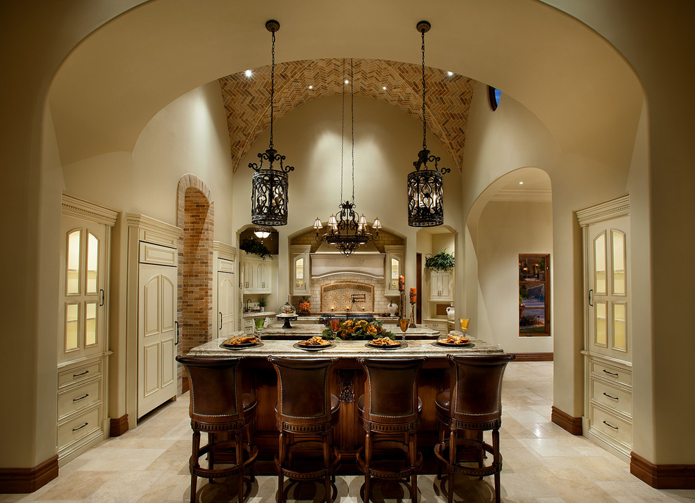 Huge u-shaped travertine floor open concept kitchen photo in Phoenix with a farmhouse sink, raised-panel cabinets, medium tone wood cabinets, granite countertops, beige backsplash, subway tile backsplash, stainless steel appliances and two islands