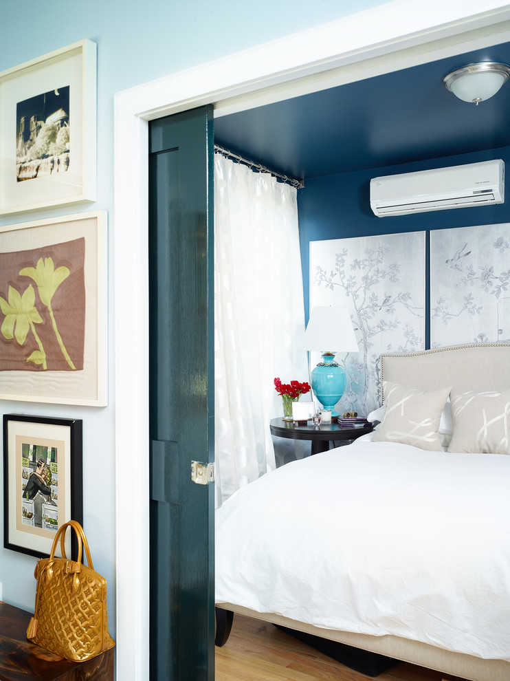This is an example of an eclectic bedroom in New York with blue walls.