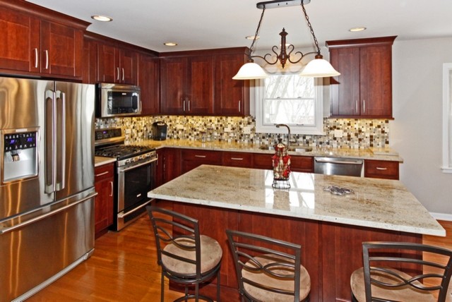 Eat-in kitchen - mid-sized transitional l-shaped medium tone wood floor eat-in kitchen idea in Chicago with an undermount sink, recessed-panel cabinets, medium tone wood cabinets, granite countertops, stainless steel appliances, gray walls and an island