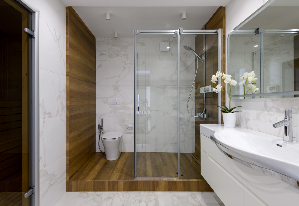 Inspiration for a mid-sized contemporary 3/4 bathroom in Novosibirsk with flat-panel cabinets, white cabinets, an alcove shower, a wall-mount toilet, brown tile, gray tile, an integrated sink, grey floor, a sliding shower screen, white benchtops, a single vanity and a floating vanity.
