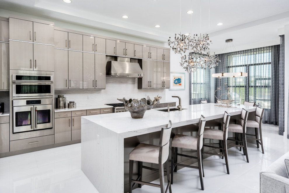 Photo of a large contemporary l-shaped open plan kitchen in Miami with an undermount sink, flat-panel cabinets, grey cabinets, marble benchtops, white splashback, marble splashback, stainless steel appliances, marble floors, with island, white floor, white benchtop and recessed.