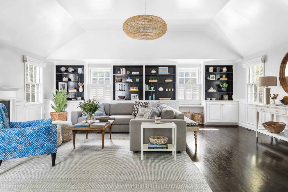 Inspiration for a transitional family room in New York with white walls, dark hardwood floors, brown floor, vaulted and decorative wall panelling.