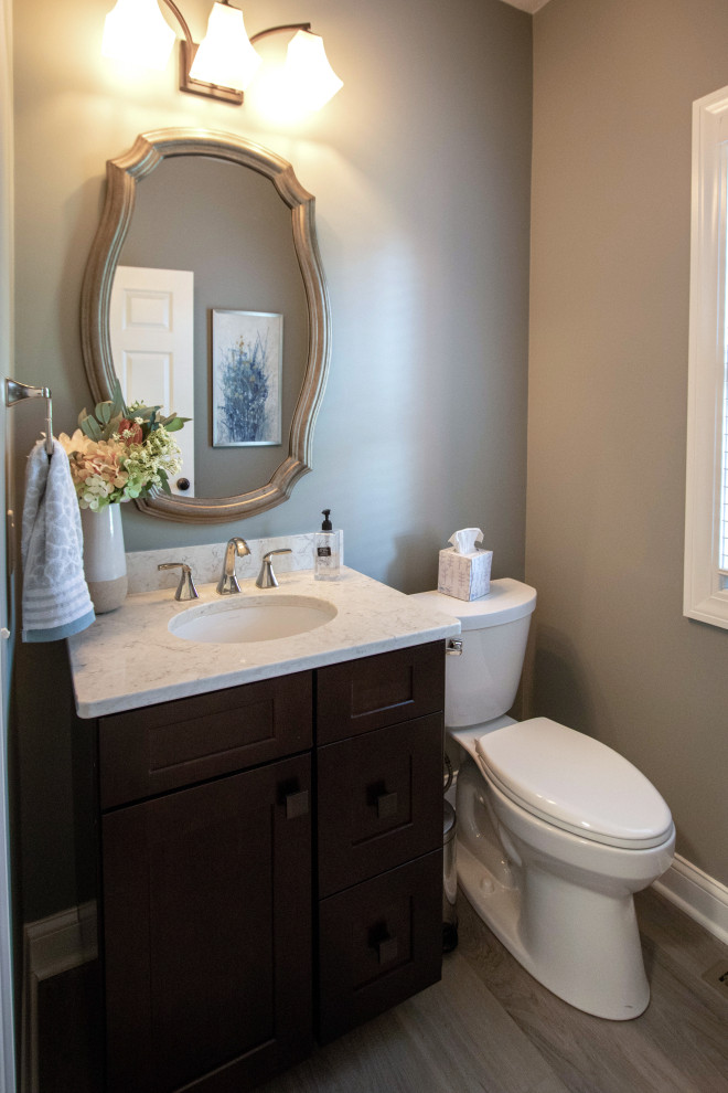 Exempel på ett litet klassiskt beige beige toalett, med släta luckor, bruna skåp, en toalettstol med separat cisternkåpa, beige väggar, vinylgolv, ett undermonterad handfat, bänkskiva i kvarts och beiget golv