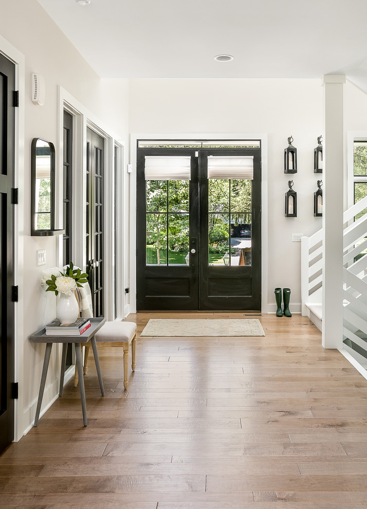 Cottage brown floor foyer photo in Chicago with white walls and a black front door