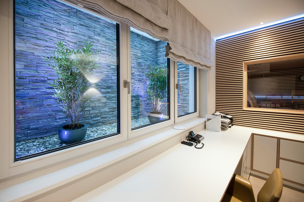 Mittelgroßes Modernes Untergeschoss mit weißer Wandfarbe, Keramikboden und grauem Boden in München