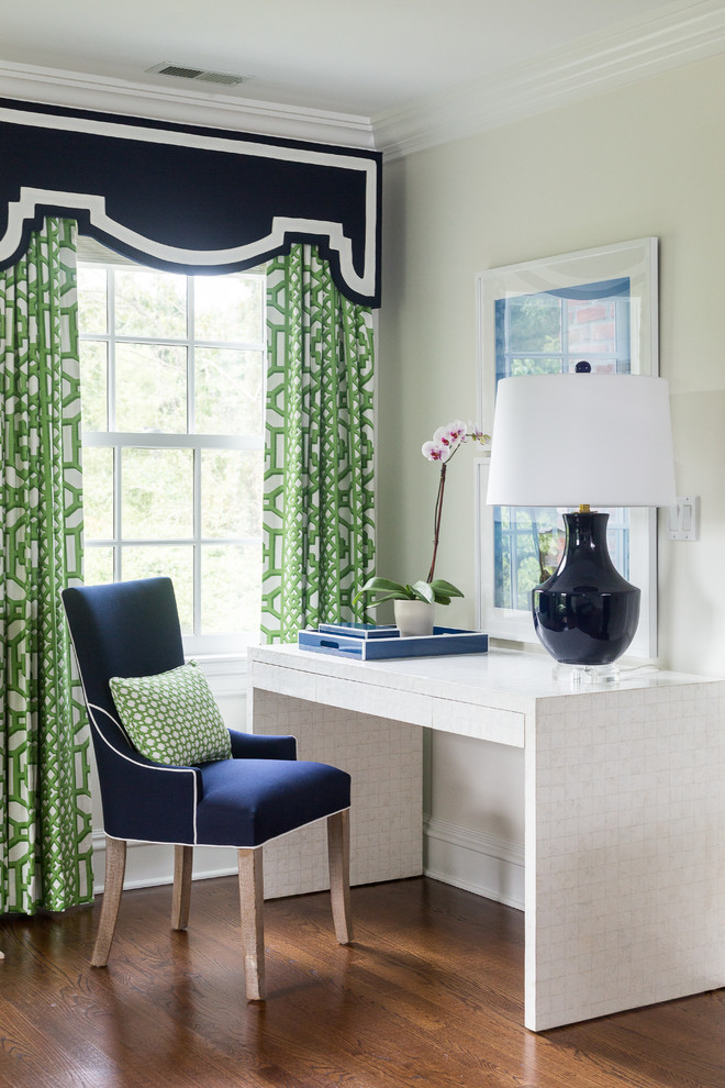 Example of a transitional master and freestanding desk medium tone wood floor study room design in New Orleans with white walls
