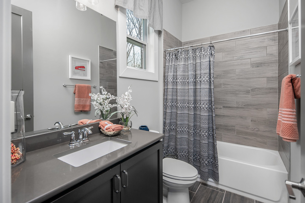 Mid-sized transitional kids bathroom in Charlotte with recessed-panel cabinets, black cabinets, a shower/bathtub combo, wood-look tile, grey walls, wood-look tile, an undermount sink, a shower curtain, a single vanity and a built-in vanity.