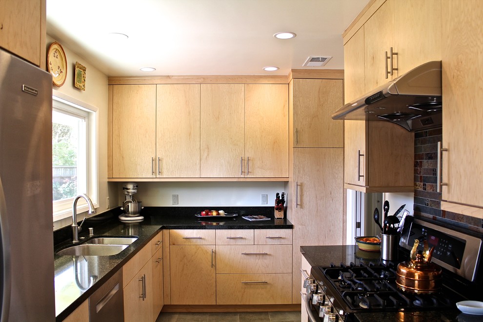 Small modern l-shaped separate kitchen in San Francisco with an undermount sink, flat-panel cabinets, light wood cabinets, granite benchtops, black splashback, slate splashback, stainless steel appliances and cement tiles.