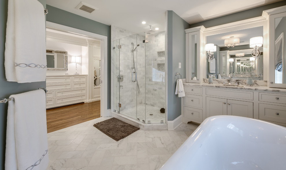 Inspiration for a large traditional master bathroom in Philadelphia with flat-panel cabinets, white cabinets, a claw-foot tub, an alcove shower, a one-piece toilet, multi-coloured tile, marble, grey walls, marble floors, an undermount sink, marble benchtops, grey floor and a hinged shower door.