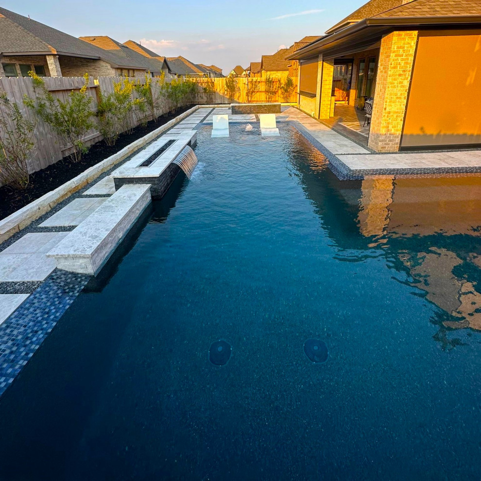 Ispirazione per una piscina moderna a "L" con pavimentazioni in pietra naturale
