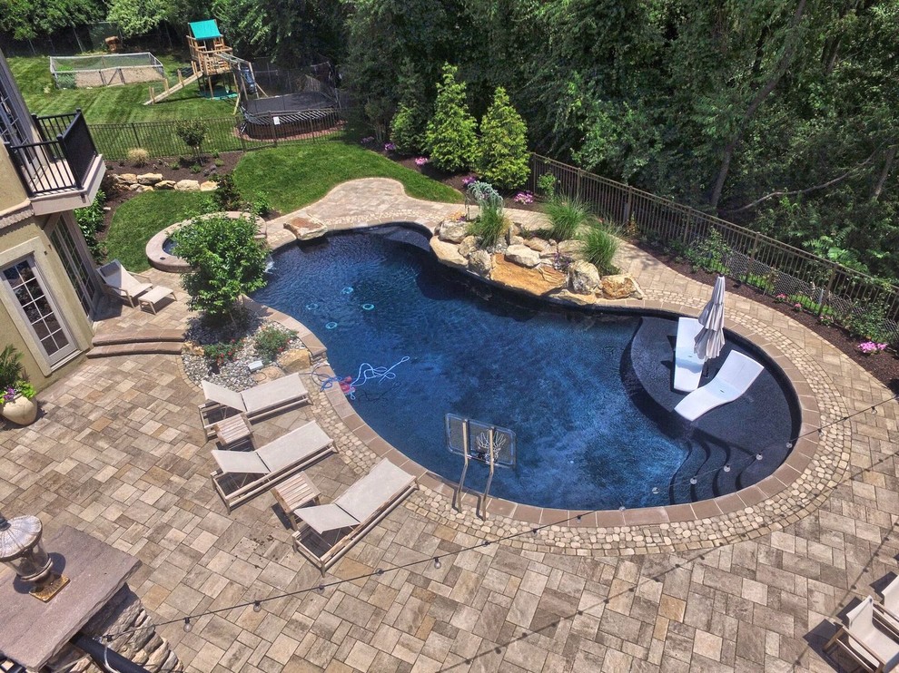 Inspiration for a large contemporary backyard kidney-shaped pool in Philadelphia with a hot tub and concrete pavers.
