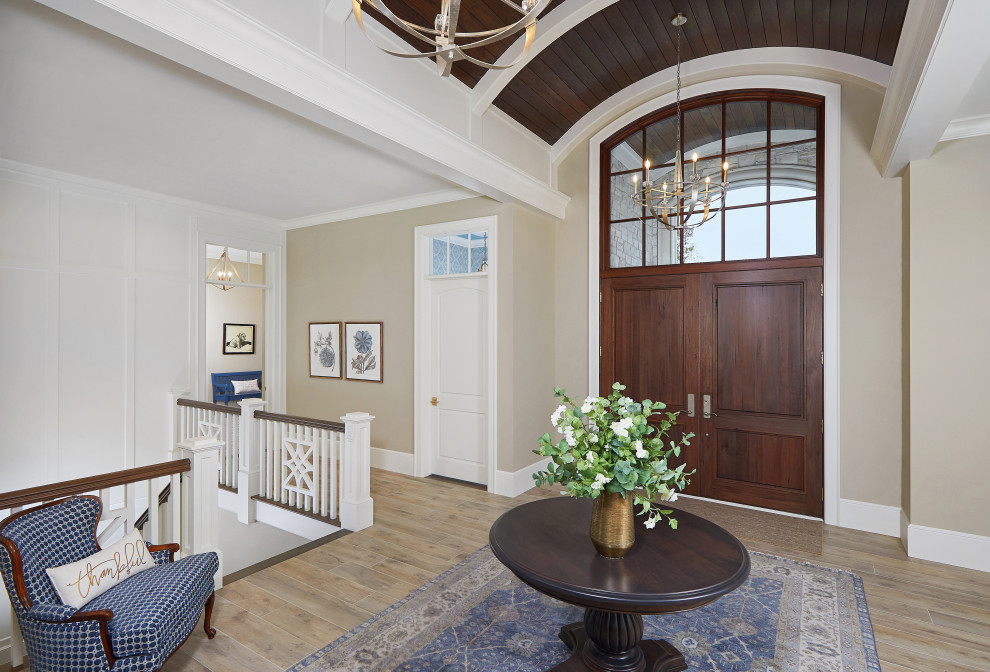 This is an example of a foyer in Grand Rapids with beige walls, dark hardwood floors, a double front door, a dark wood front door, brown floor, vaulted and panelled walls.