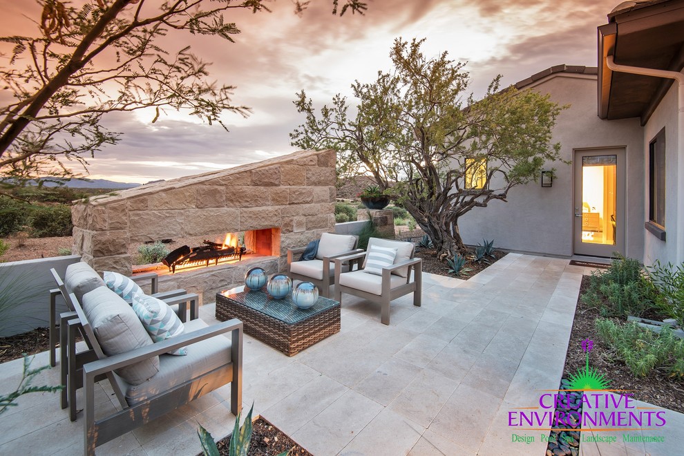 This is an example of a medium sized traditional front patio in Phoenix with a fire feature and concrete paving.