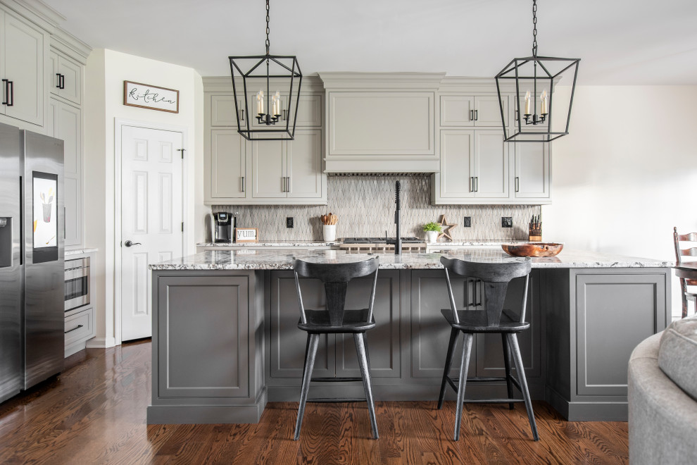 Example of a large farmhouse l-shaped medium tone wood floor and brown floor open concept kitchen design in Nashville with a farmhouse sink, beaded inset cabinets, gray cabinets, granite countertops, gray backsplash, ceramic backsplash, stainless steel appliances, an island and white countertops