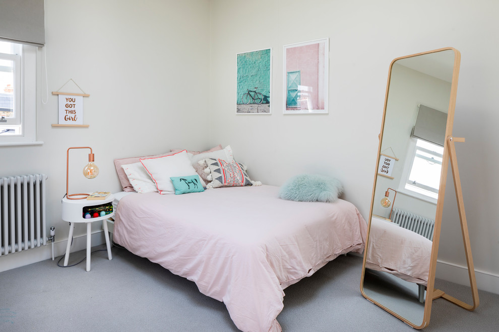 This is an example of a large contemporary kids' room for girls in London with grey walls, carpet and grey floor.