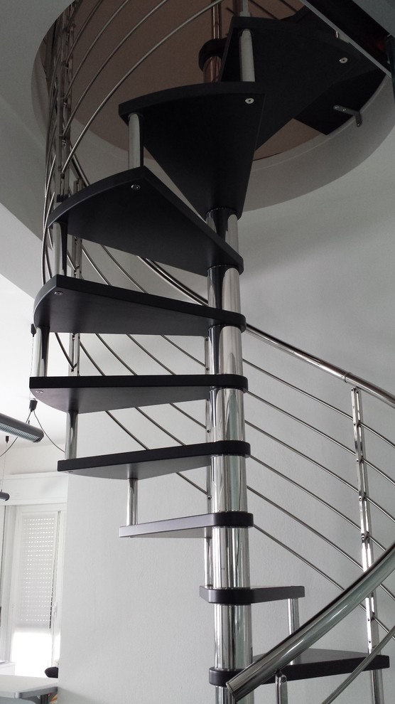 Inspiration for a small modern wood spiral staircase in Milan with open risers and metal railing.