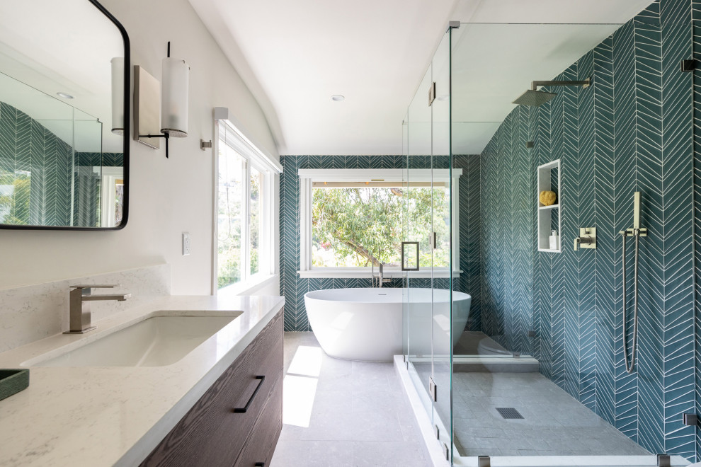 Photo of a large contemporary master bathroom in Los Angeles with flat-panel cabinets, dark wood cabinets, a freestanding tub, a double shower, a one-piece toilet, green tile, glass tile, white walls, an undermount sink, engineered quartz benchtops, grey floor, a hinged shower door, white benchtops, a double vanity and a floating vanity.