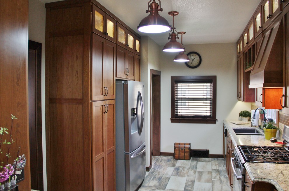 Inspiration for a mid-sized transitional galley ceramic tile enclosed kitchen remodel with an undermount sink, shaker cabinets, medium tone wood cabinets, quartz countertops, beige backsplash, stone tile backsplash, stainless steel appliances and a peninsula