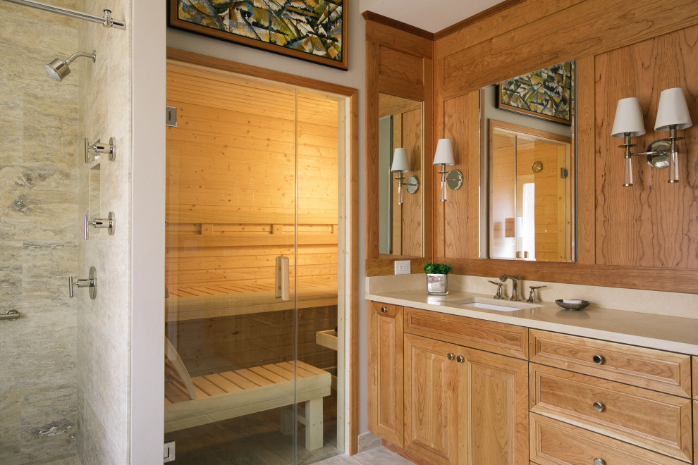 Inspiration för stora klassiska beige en-suite badrum, med luckor med upphöjd panel, bruna skåp, en kantlös dusch, beige kakel, travertinkakel, beige väggar, travertin golv, ett undermonterad handfat, marmorbänkskiva, beiget golv och dusch med skjutdörr