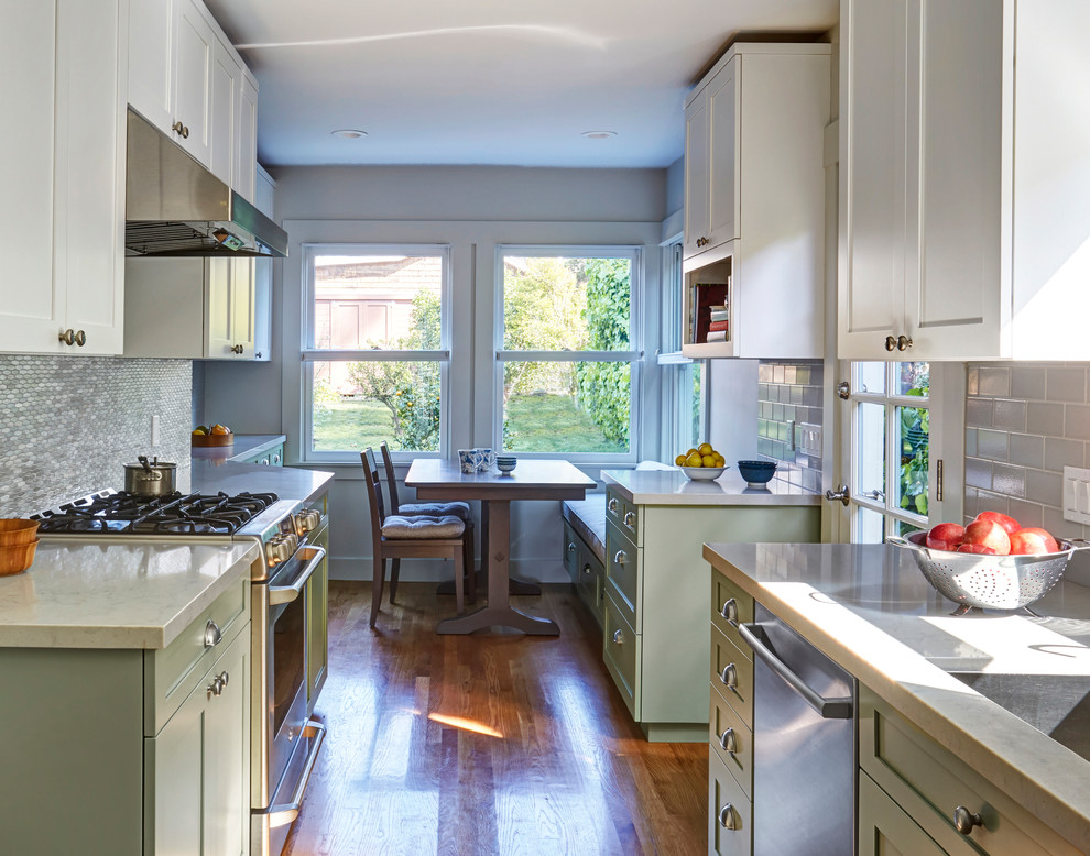 Inspiration for a mid-sized transitional galley separate kitchen in San Francisco with an undermount sink, shaker cabinets, green cabinets, quartz benchtops, grey splashback, ceramic splashback, stainless steel appliances, light hardwood floors, no island, brown floor and grey benchtop.