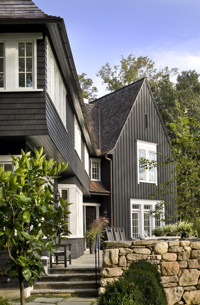 Inspiration for a large traditional two-storey black exterior in New York with wood siding, a gable roof, board and batten siding and shingle siding.