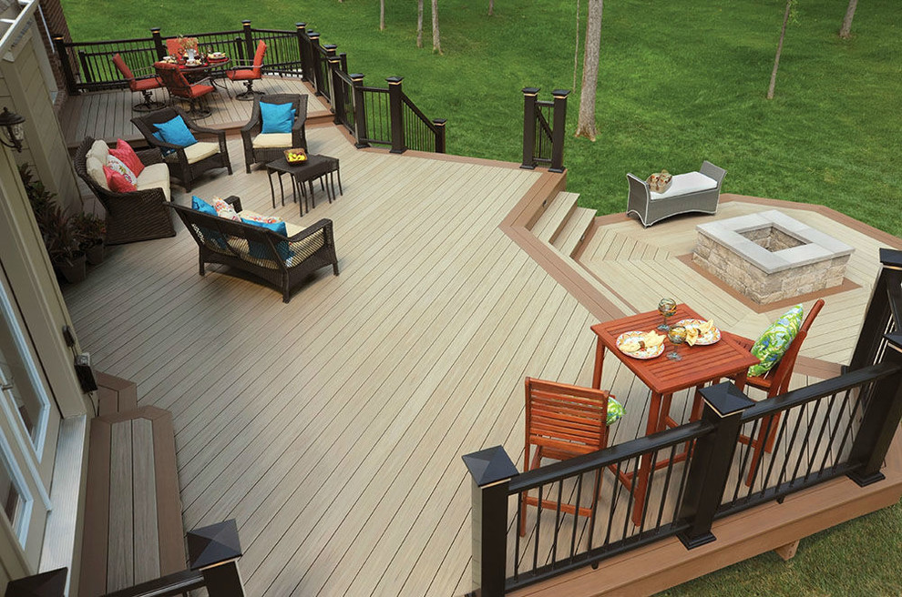 This is an example of a large traditional backyard deck in Cleveland with a fire feature and no cover.