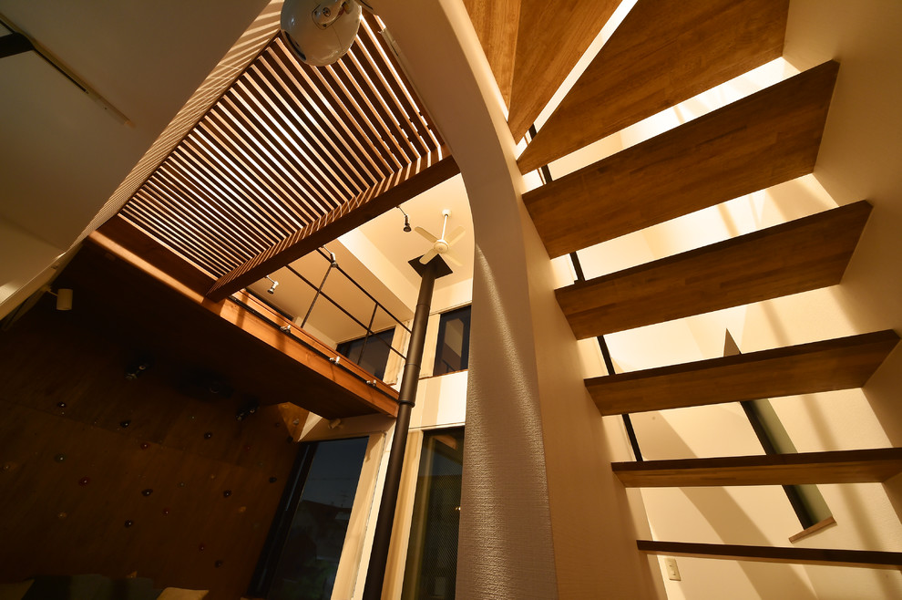 Diseño de escalera suspendida sin contrahuella con escalones de madera y barandilla de metal