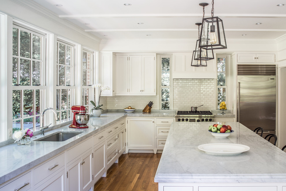 Inspiration for a large traditional separate kitchen in DC Metro with an undermount sink, shaker cabinets, white cabinets, marble benchtops, white splashback, subway tile splashback, stainless steel appliances, with island, brown floor, medium hardwood floors and grey benchtop.