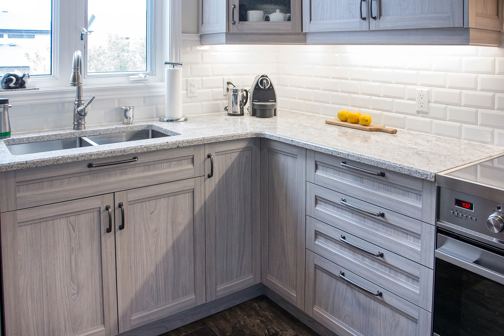 Open concept kitchen - mid-sized transitional u-shaped porcelain tile and beige floor open concept kitchen idea in Toronto with an undermount sink, shaker cabinets, light wood cabinets, quartz countertops, white backsplash, subway tile backsplash, stainless steel appliances and a peninsula