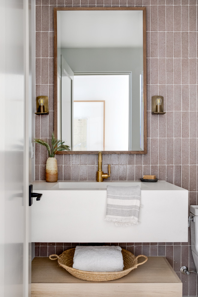 Example of a small trendy pink tile and porcelain tile powder room design in Orange County with open cabinets, light wood cabinets, white countertops and a floating vanity