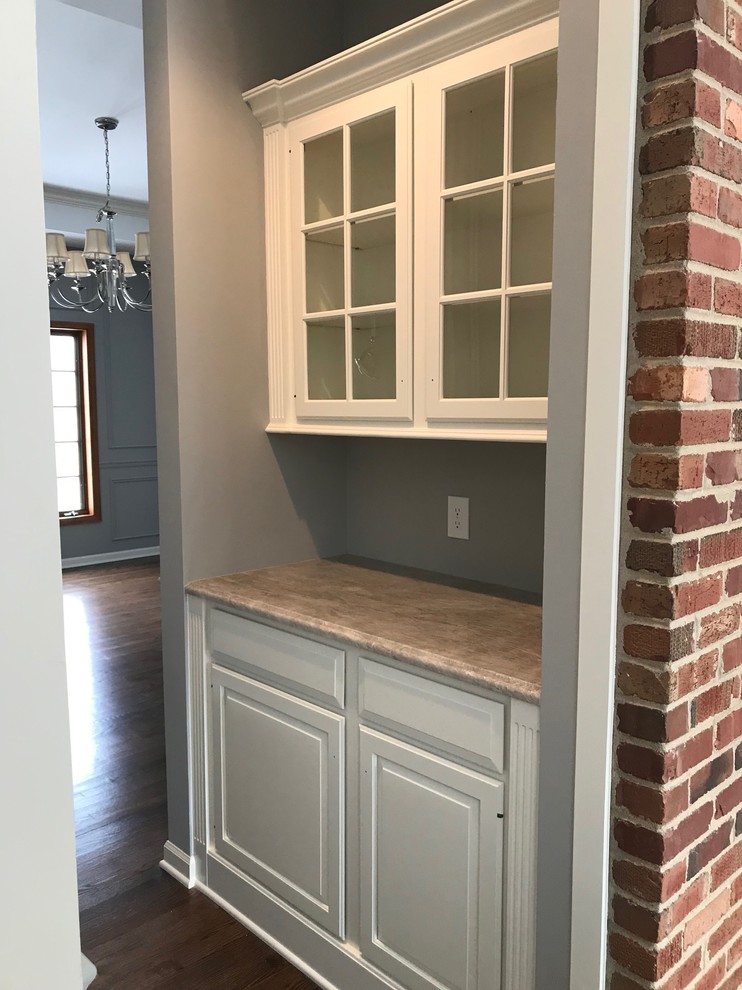 Small traditional galley kitchen pantry in Chicago with a farmhouse sink, raised-panel cabinets, medium wood cabinets, laminate benchtops, grey splashback, timber splashback, stainless steel appliances, medium hardwood floors, no island, brown floor and beige benchtop.