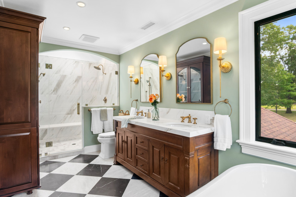 Large french country master porcelain tile and white tile marble floor, double-sink and multicolored floor bathroom photo in New York with raised-panel cabinets, brown cabinets, a two-piece toilet, green walls, quartz countertops, a hinged shower door, white countertops, a freestanding vanity and an undermount sink