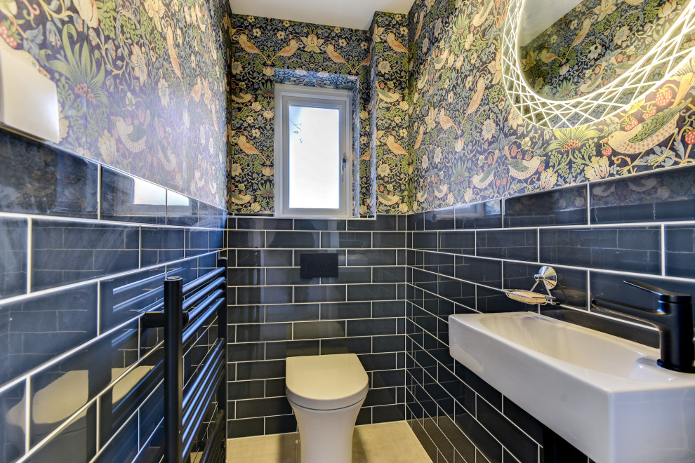 На фото: маленький туалет: освещение в стиле фьюжн с инсталляцией, синей плиткой, керамической плиткой, разноцветными стенами, полом из керамогранита, подвесной раковиной, серым полом и обоями на стенах для на участке и в саду с