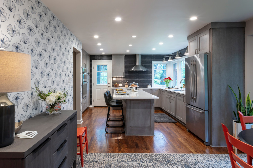 Trendy u-shaped medium tone wood floor and brown floor eat-in kitchen photo with an undermount sink, shaker cabinets, gray cabinets, quartz countertops, gray backsplash, ceramic backsplash, stainless steel appliances, an island and gray countertops