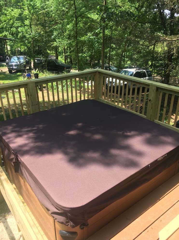 Example of a mid-sized transitional backyard rectangular hot tub design with decking