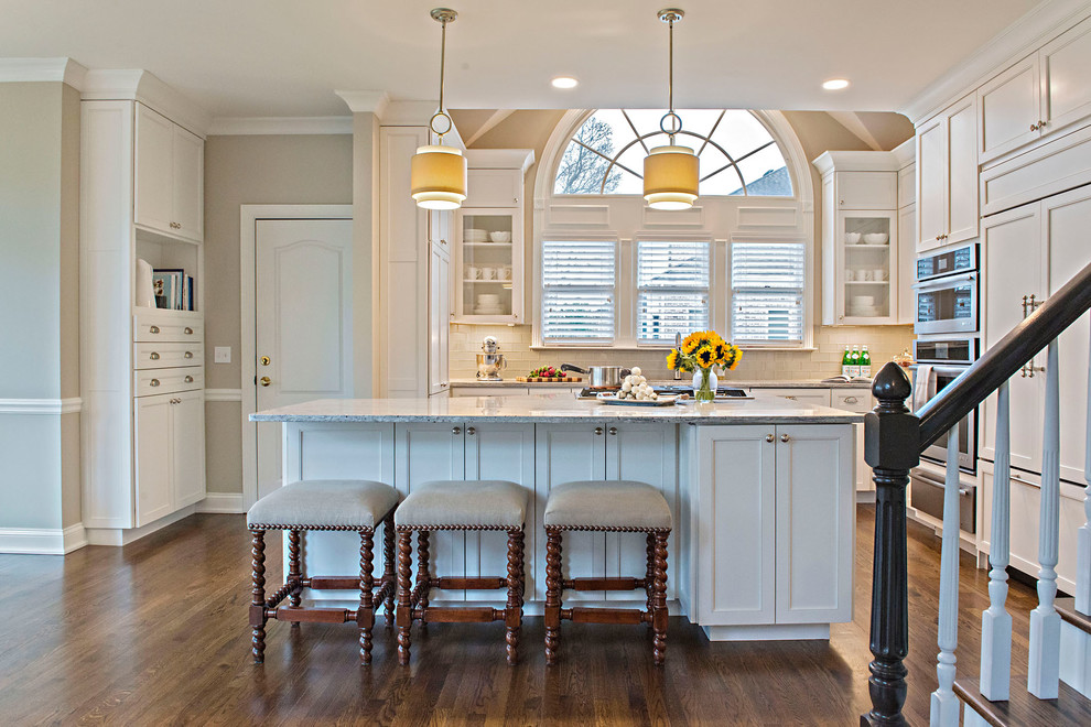 Example of a mid-sized transitional l-shaped dark wood floor and brown floor eat-in kitchen design in Nashville with an undermount sink, recessed-panel cabinets, white cabinets, granite countertops, white backsplash, glass tile backsplash, stainless steel appliances, an island and gray countertops