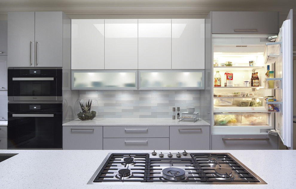 This is an example of a mid-sized modern galley eat-in kitchen in Oklahoma City with a single-bowl sink, glass-front cabinets, grey cabinets, quartz benchtops, glass tile splashback, stainless steel appliances, porcelain floors, a peninsula and multi-coloured splashback.