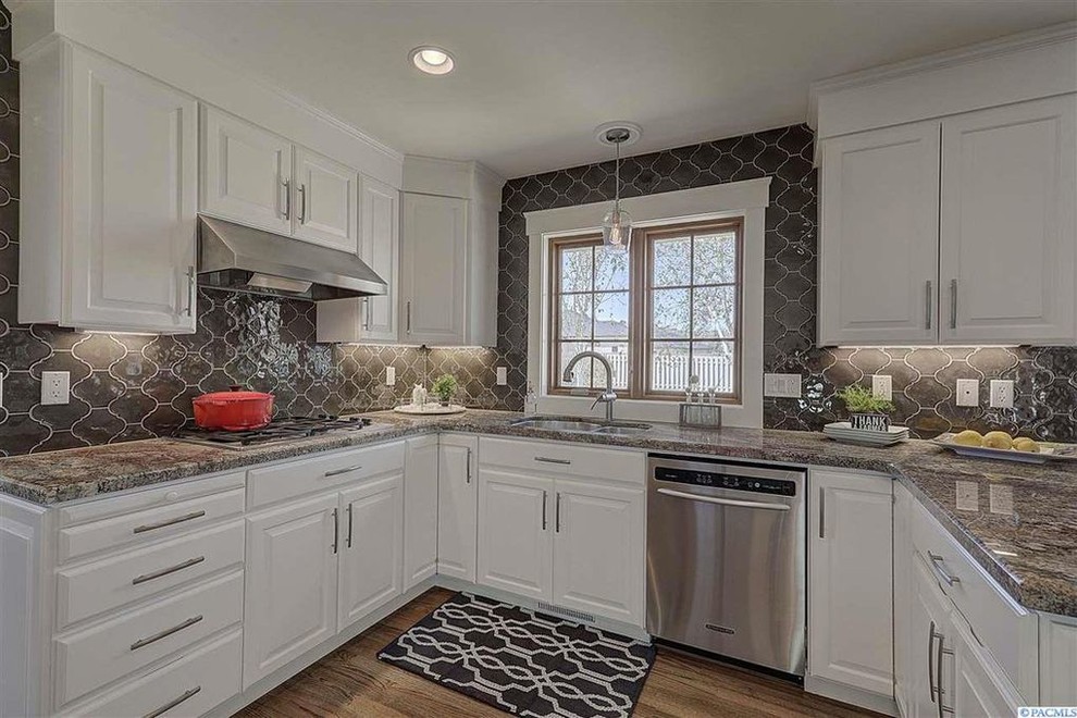 Eat-in kitchen - transitional u-shaped medium tone wood floor and brown floor eat-in kitchen idea in Seattle with an undermount sink, raised-panel cabinets, white cabinets, granite countertops, brown backsplash, porcelain backsplash, stainless steel appliances and brown countertops