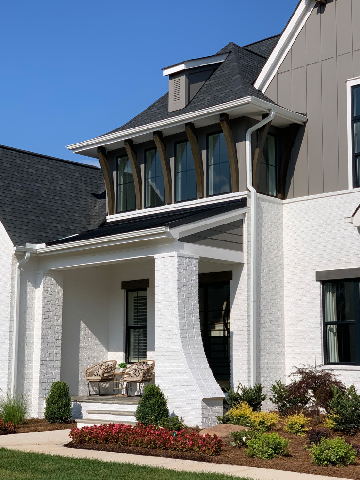 Großes, Zweistöckiges Klassisches Einfamilienhaus mit gestrichenen Ziegeln, weißer Fassadenfarbe, Walmdach, Blechdach, schwarzem Dach und Wandpaneelen in Charlotte