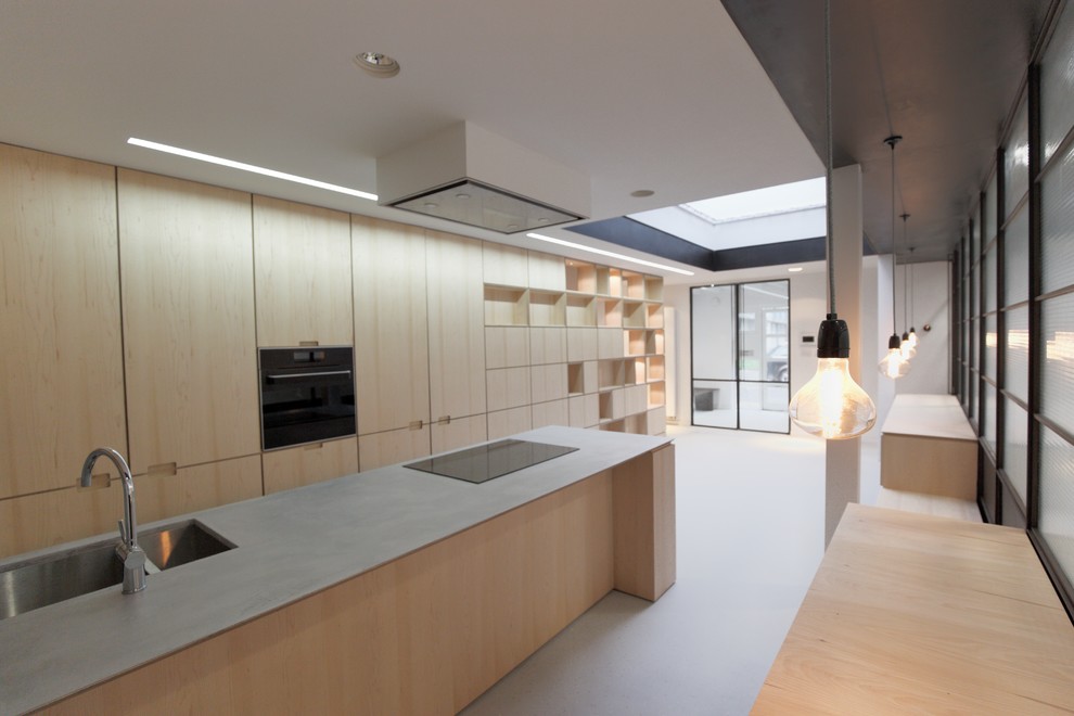 This is an example of a large modern u-shaped kitchen in London with a double-bowl sink, yellow cabinets, concrete benchtops, panelled appliances, terrazzo floors, with island, grey floor and grey benchtop.