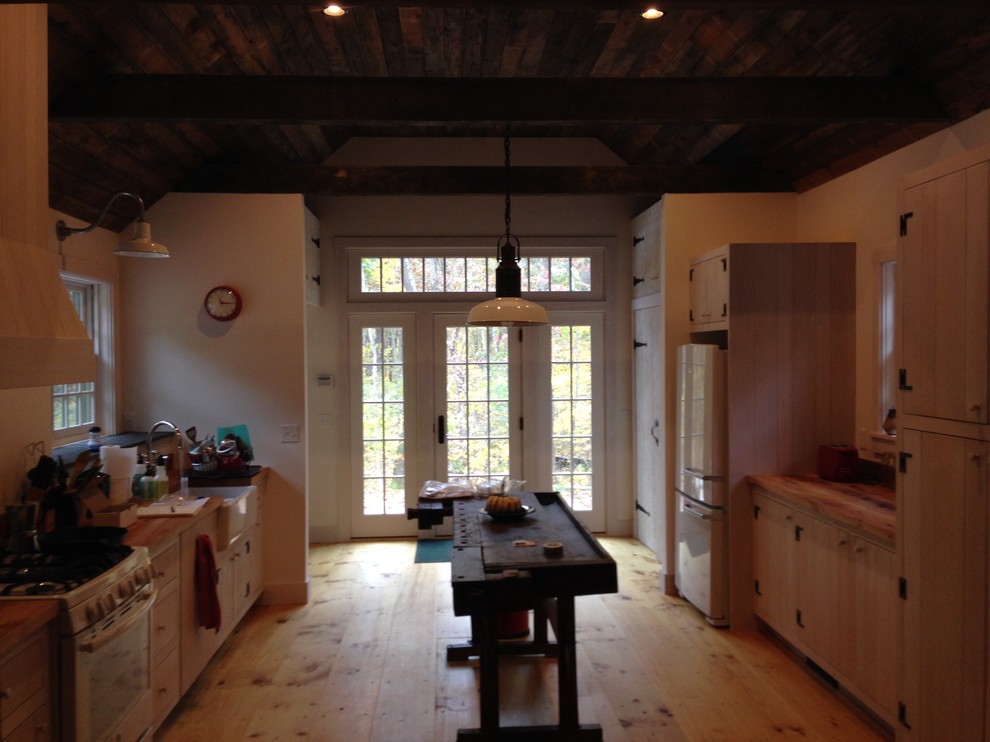 This is an example of a mid-sized country galley kitchen in New York with a farmhouse sink and wood benchtops.