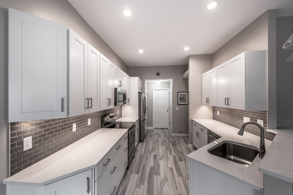 Eat-in kitchen - mid-sized transitional galley porcelain tile and multicolored floor eat-in kitchen idea with an undermount sink, recessed-panel cabinets, white cabinets, quartz countertops, gray backsplash, ceramic backsplash, stainless steel appliances, a peninsula and white countertops