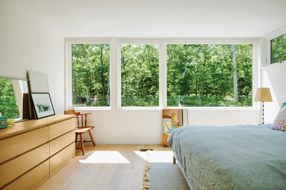 На фото: хозяйская спальня среднего размера в современном стиле с белыми стенами, светлым паркетным полом и бежевым полом с