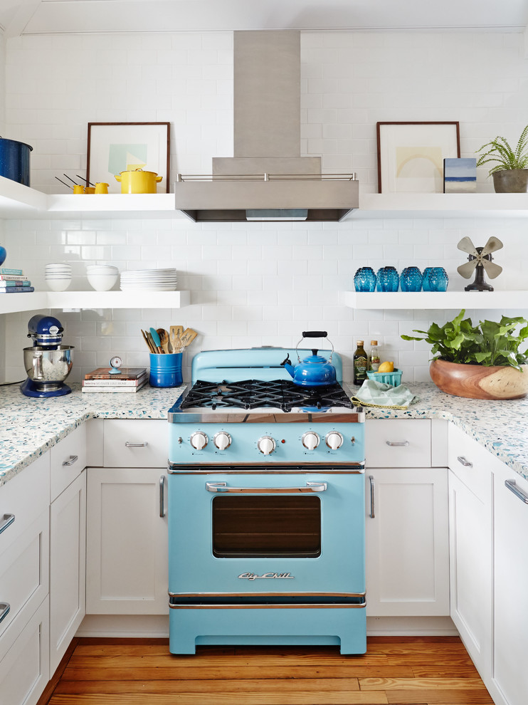 This is an example of a beach style u-shaped kitchen in Charleston with shaker cabinets, white cabinets, white splashback, subway tile splashback, coloured appliances and medium hardwood floors.
