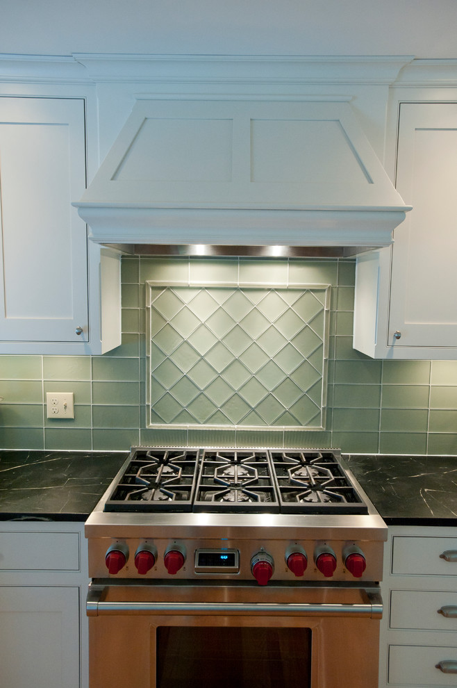 Transitional light wood floor kitchen pantry photo in Boston with a farmhouse sink, flat-panel cabinets, white cabinets, granite countertops, green backsplash, glass tile backsplash and stainless steel appliances