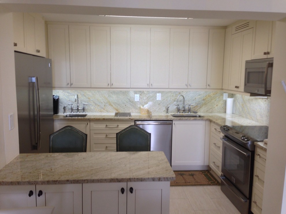 Kitchen pantry - mid-sized transitional u-shaped travertine floor kitchen pantry idea in Miami with an undermount sink, shaker cabinets, white cabinets, granite countertops, multicolored backsplash, stone slab backsplash, stainless steel appliances and a peninsula