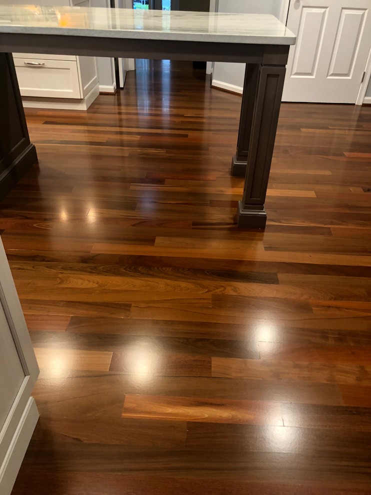 Example of a large transitional galley medium tone wood floor and brown floor eat-in kitchen design in Baltimore with a single-bowl sink, recessed-panel cabinets, white cabinets, quartzite countertops, gray backsplash, glass tile backsplash, stainless steel appliances, an island and multicolored countertops
