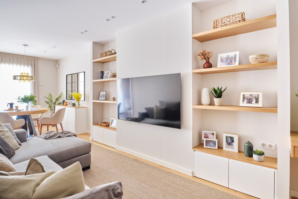 Medium sized scandinavian open plan games room in Barcelona with a reading nook, white walls, medium hardwood flooring, a wall mounted tv and brown floors.