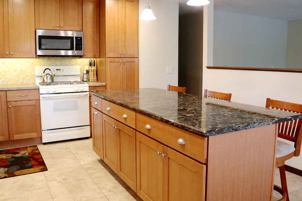 Photo of a mid-sized l-shaped separate kitchen in Minneapolis with an integrated sink, shaker cabinets, medium wood cabinets, quartzite benchtops, beige splashback, glass tile splashback, white appliances and with island.