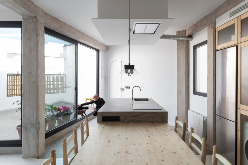 Idéer för att renovera ett mellanstort funkis grå linjärt grått kök och matrum, med en integrerad diskho, luckor med glaspanel, skåp i ljust trä, bänkskiva i betong, grått stänkskydd, ljust trägolv, en köksö och vitt golv